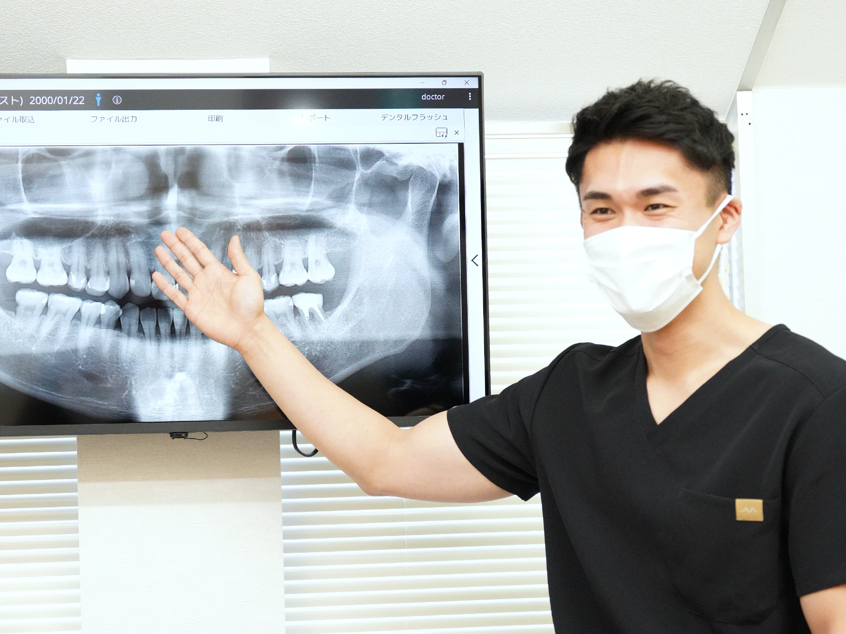 アンンサンブル歯科 アンンサンブル歯科 青葉台で、歯科医師がレントゲン画像を用いて患者に説明している診療風景