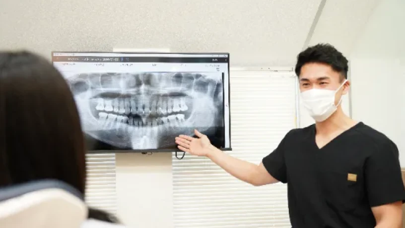 アンンサンブル歯科 青葉台で歯科医師がレントゲン画像を用いて治療説明を行っている様子